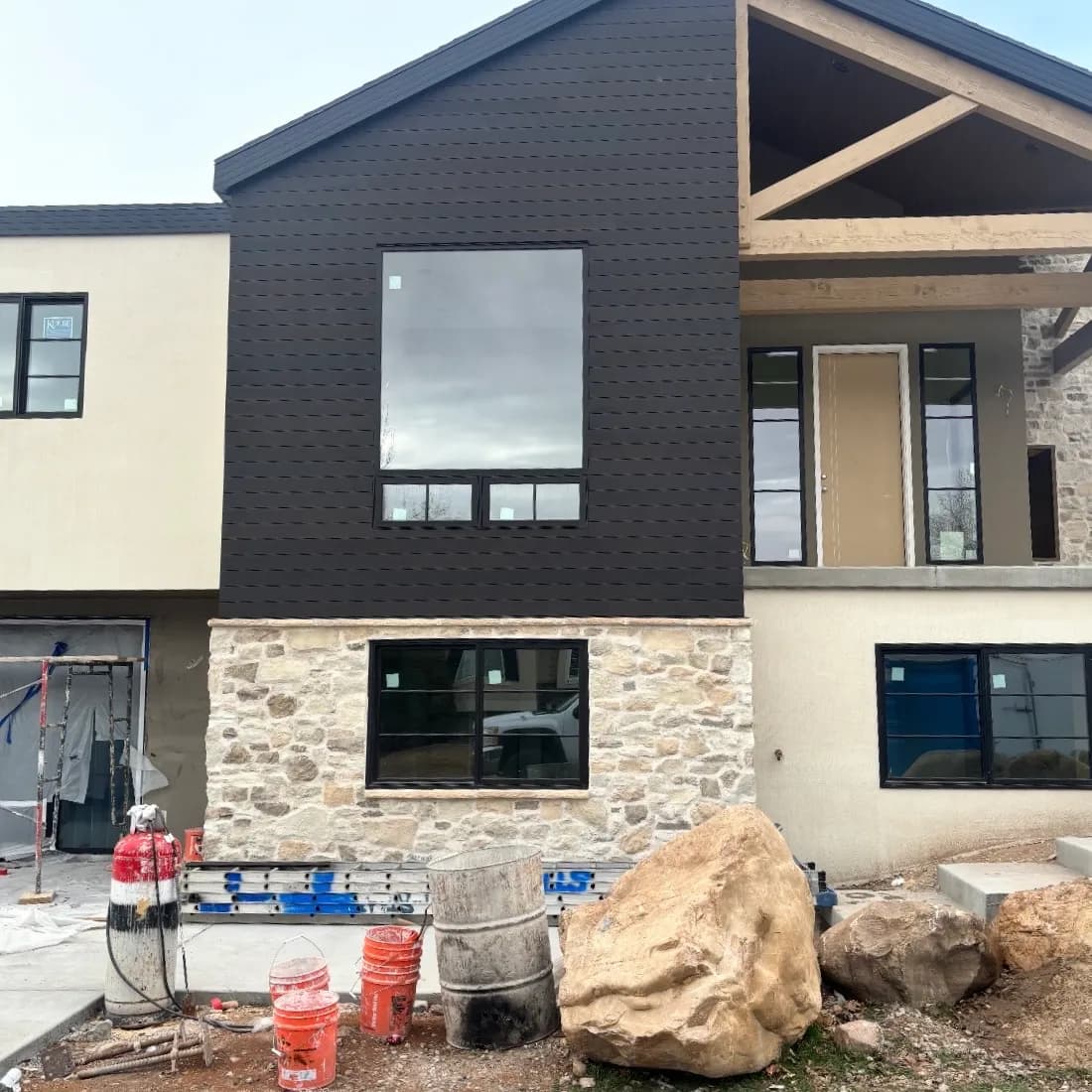 Modern exterior with dark siding and stone